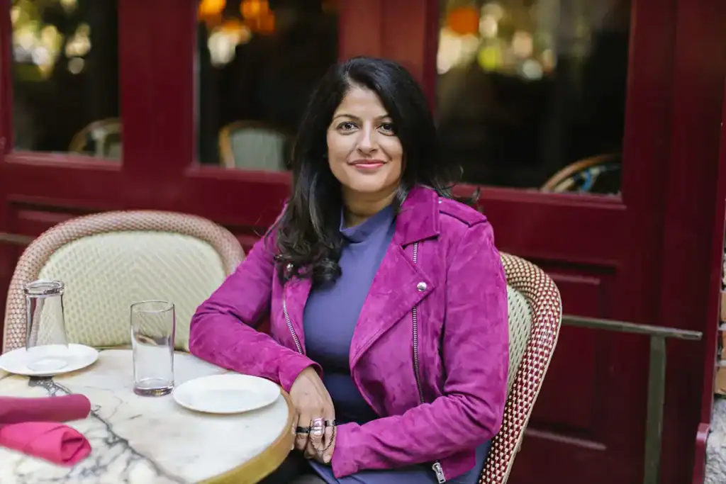 dr aditi u joshi sitting at a table in a purple jacket